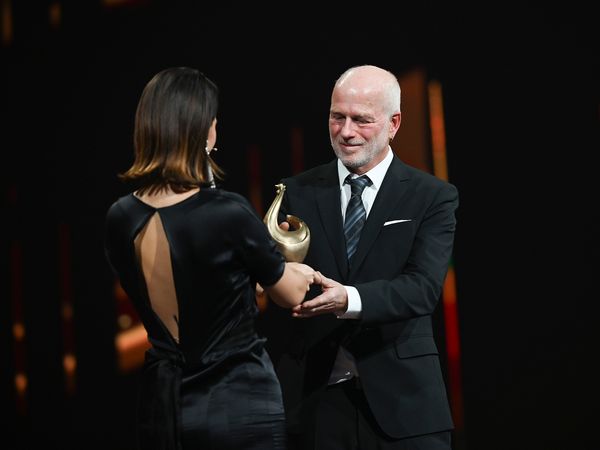 Yara Hoffmann überreicht Peter Nitschke eine Goldene Henne. 