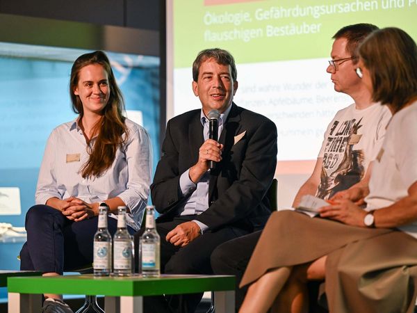 Menschen diskutieren auf einer Bühne beim 3. Wildbienensymposium am 23. September Museum der Natur Hamburg. V.l.n.r: Dr. Sophie Ogan, Dr. Hannes Petrischak, Dr. Ulrich Kotthoff und Moderatorin Dr. Tanja Busse